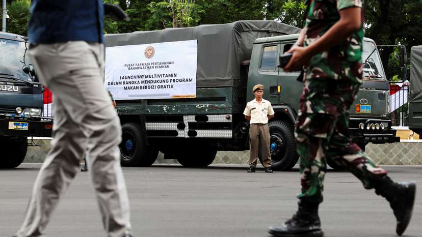 An Indonesian military officer stands beside a truck carrying multivitamins to be used in the government's free meal programme before launch in Jakarta