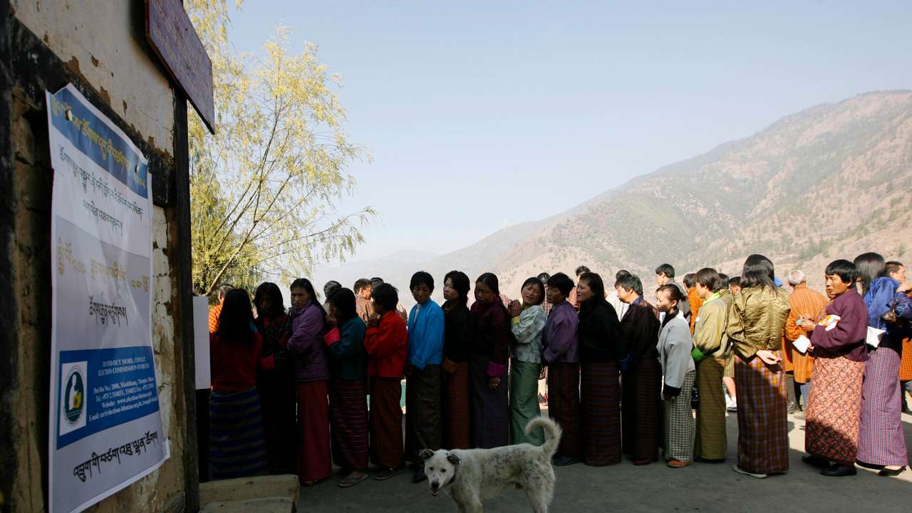 FILE PHOTO: Bhutanese voters stand in a queue outside a polling station to cast their ballot in Thimpu
