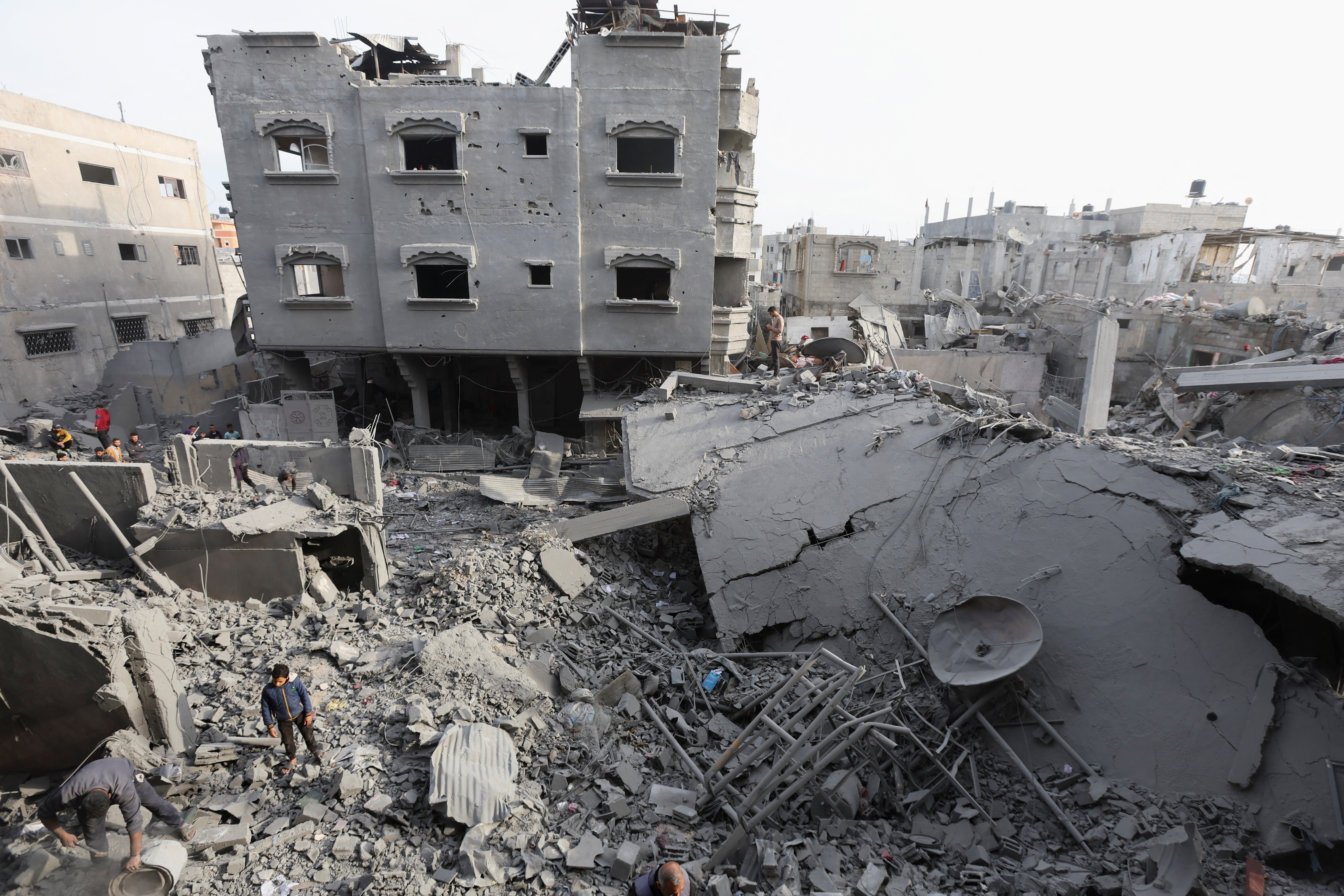 Palestinians inspect damage at the site of an Israeli strike on a house, at Nuseirat refugee camp