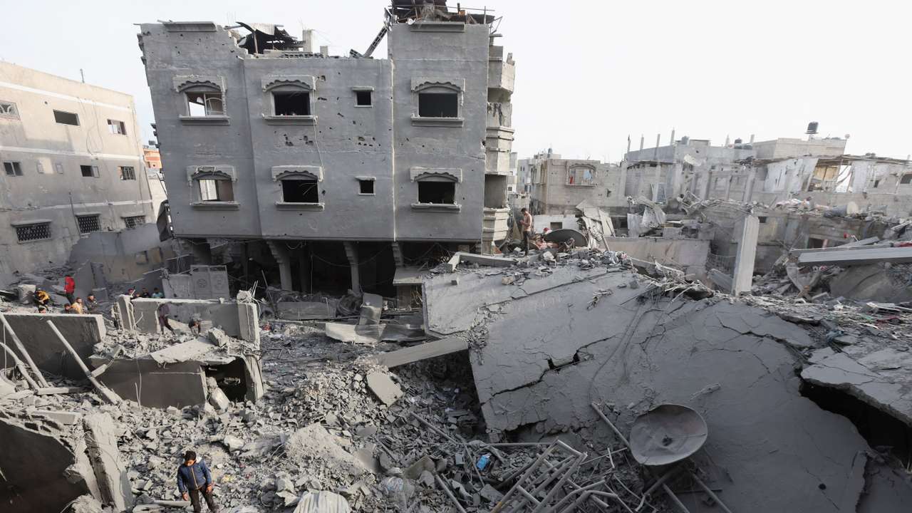 Palestinians inspect damage at the site of an Israeli strike on a house, at Nuseirat refugee camp