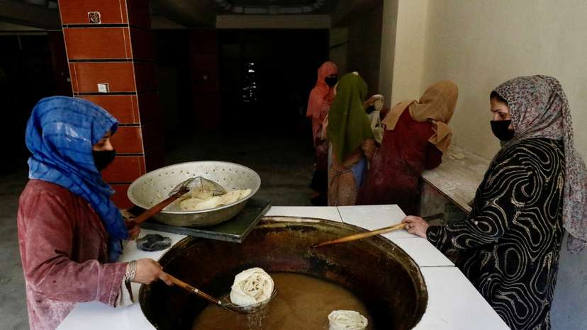 FILE PHOTO: Afghan women fry traditional cookies inside a bakery, in Kabul