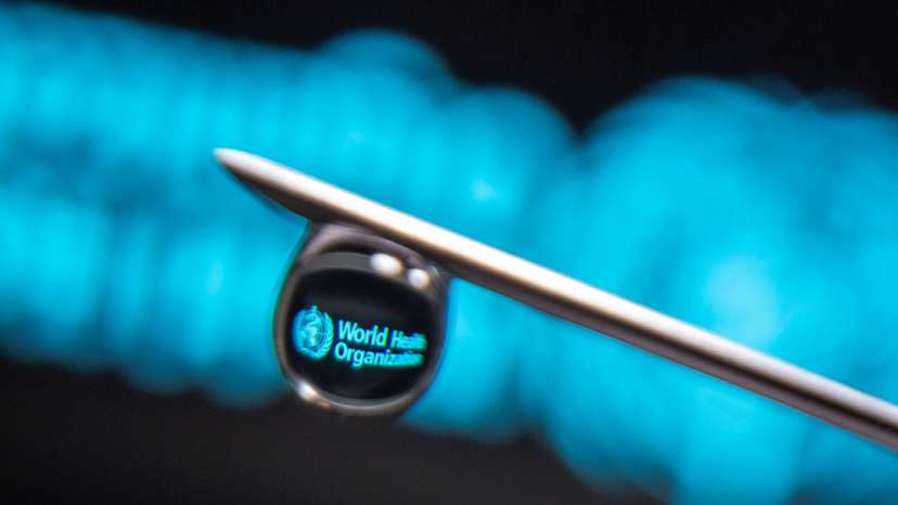 FILE PHOTO: World Health Organization logo is reflected in a drop on a syringe needle in this illustration photo