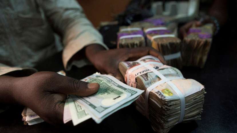 FILE PHOTO: A trader changes dollars with naira at a currency exchange store in Lagos