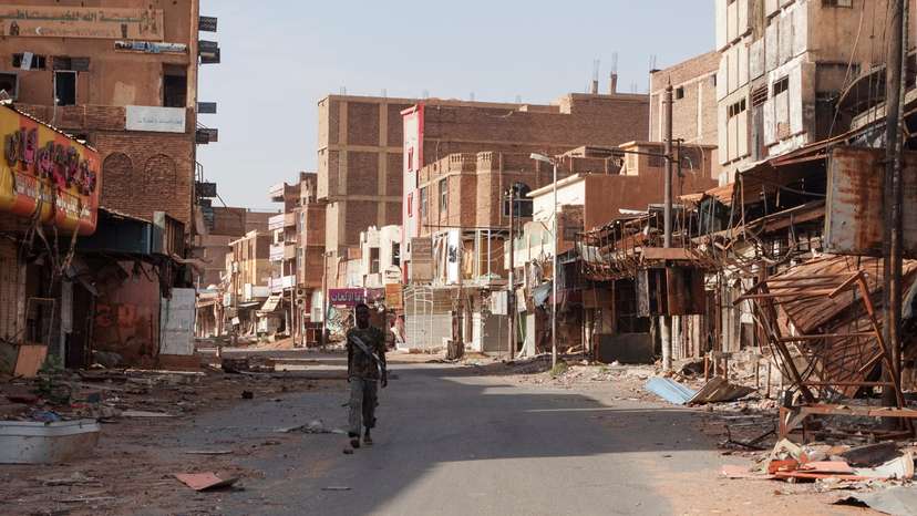 FILE PHOTO: A member of the Sudanese Armed forces walks between damaged buildings, in Omdurman