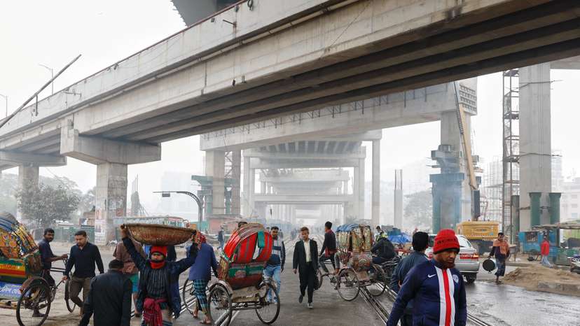 People and vehicles pass through rail tracks at the Karwan Bazar area, in Dhaka