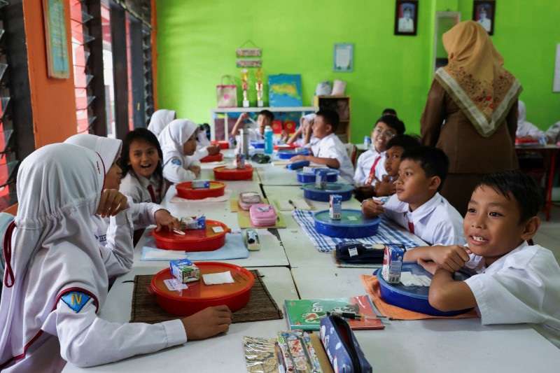 Students attend a free-lunch programme trial at an elementary school in Tangerang