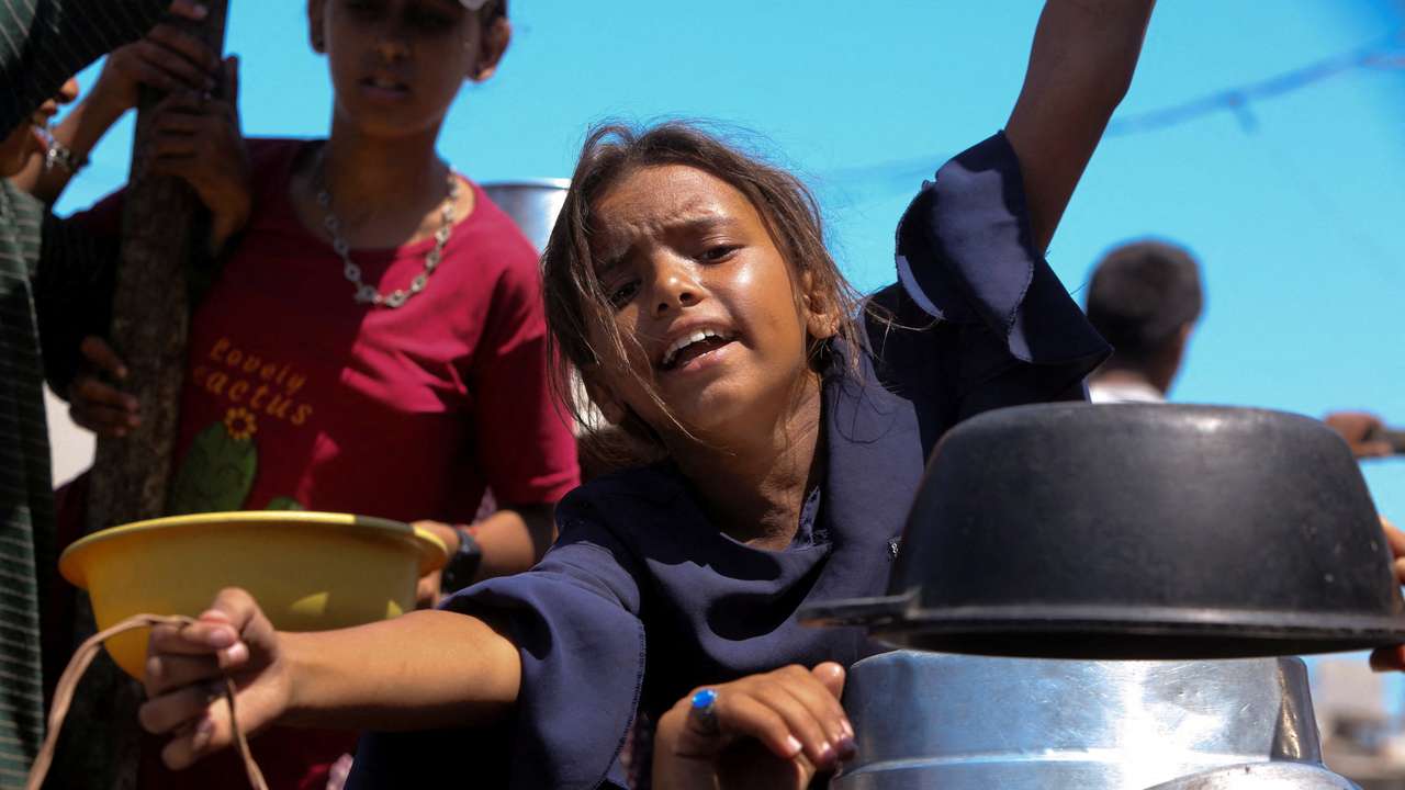 Palestinians wait to receive food from a charity kitchen, amid a hunger crisis, in Khan Younis