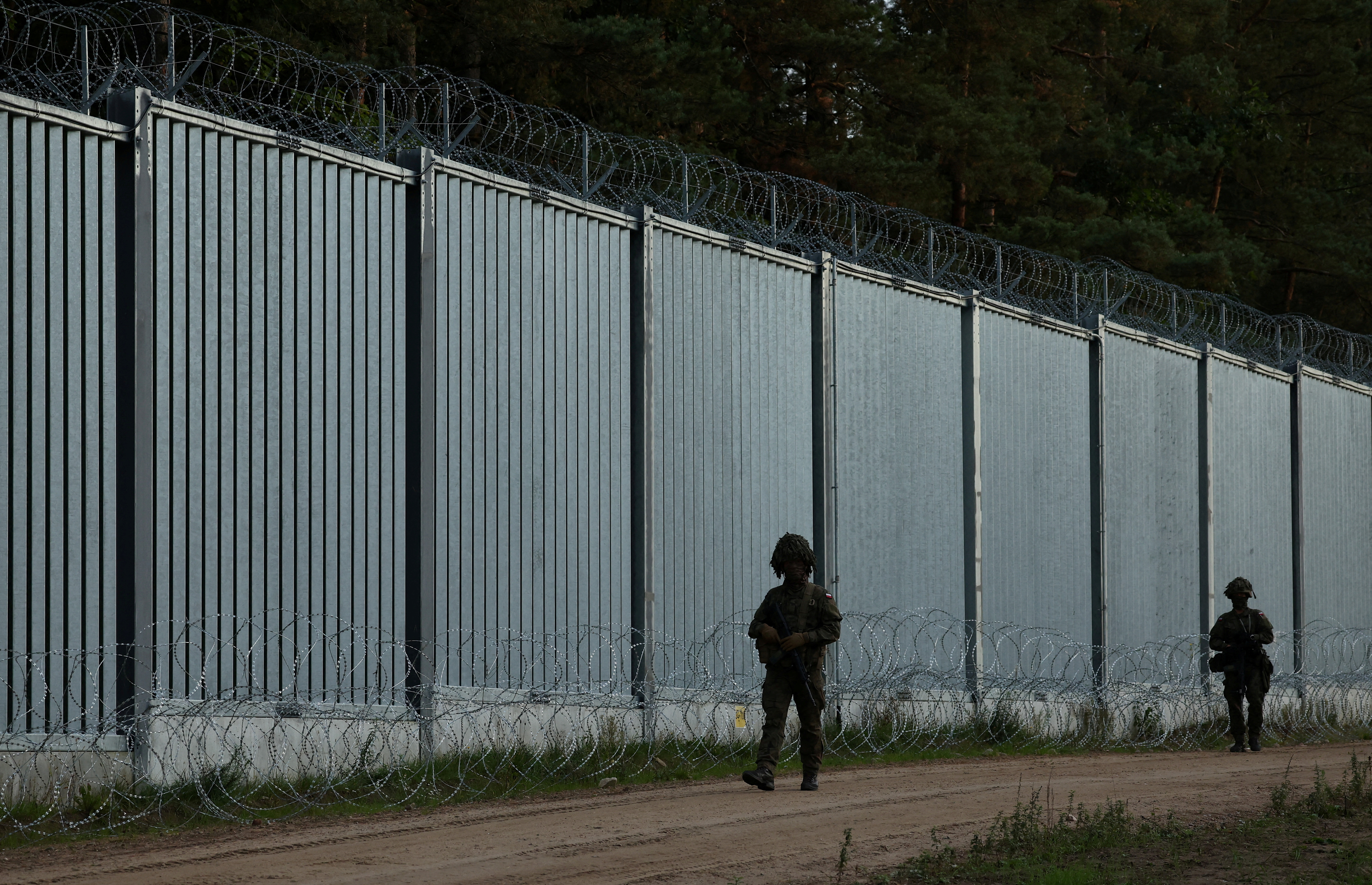 FILE PHOTO: Border guards officers are seen near the fence on the Polish-Belarusian border, during the migrant crisis, in Opaka Duza