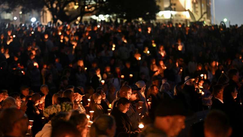 People gather for a candlelight vigil on Bondi Beach to pay respects to the victims of a fatal stabbing attack at a shopping centre in Sydney