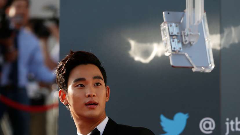 South Korean actor Kim Soo-hyun looks at a tablet as he arrives at the 50th Baeksang Arts Awards in Seoul