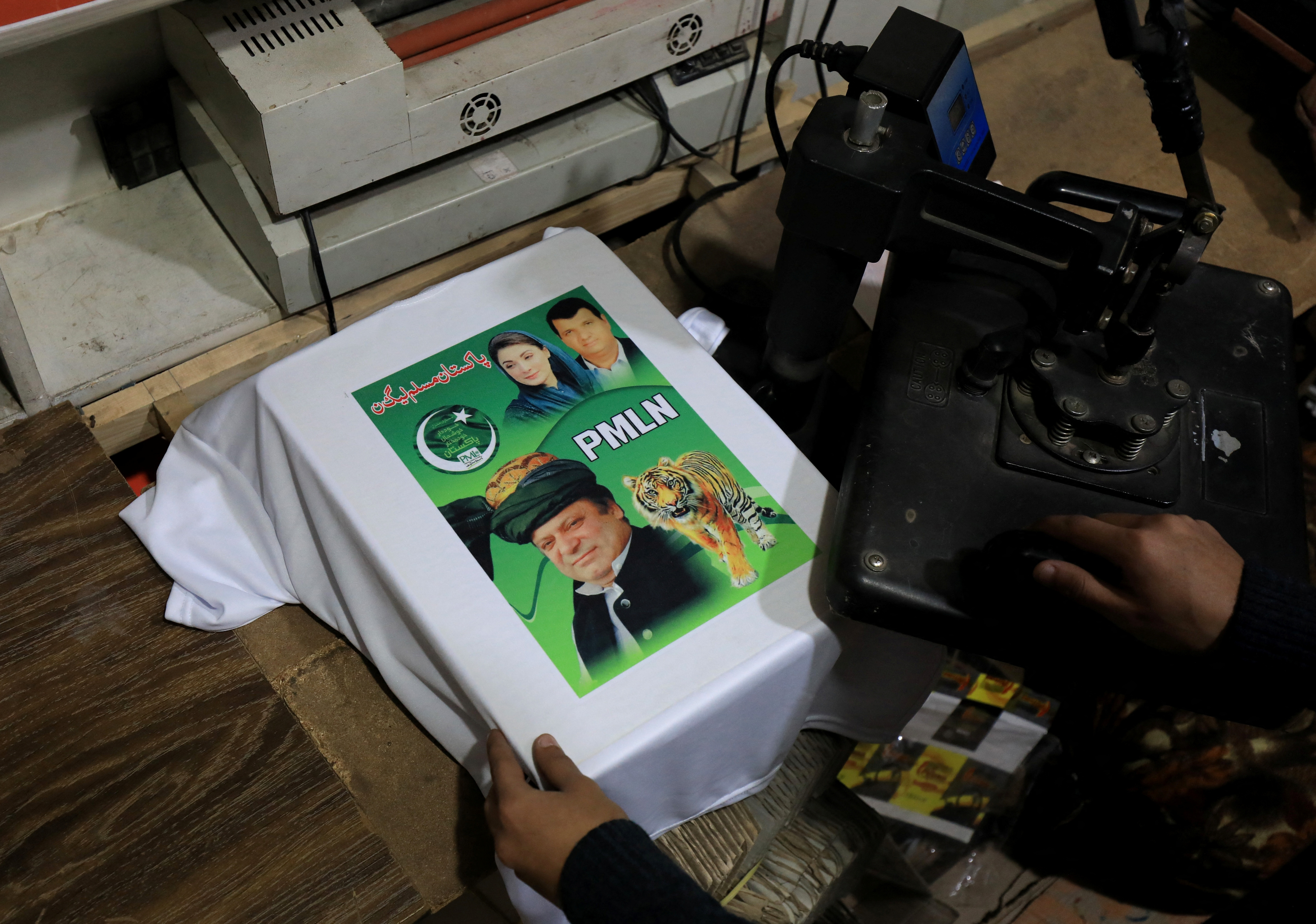 A worker prints a poster depicting Pakistan's former Prime Minister Nawaz Sharif on a t-shirt, in Peshawar