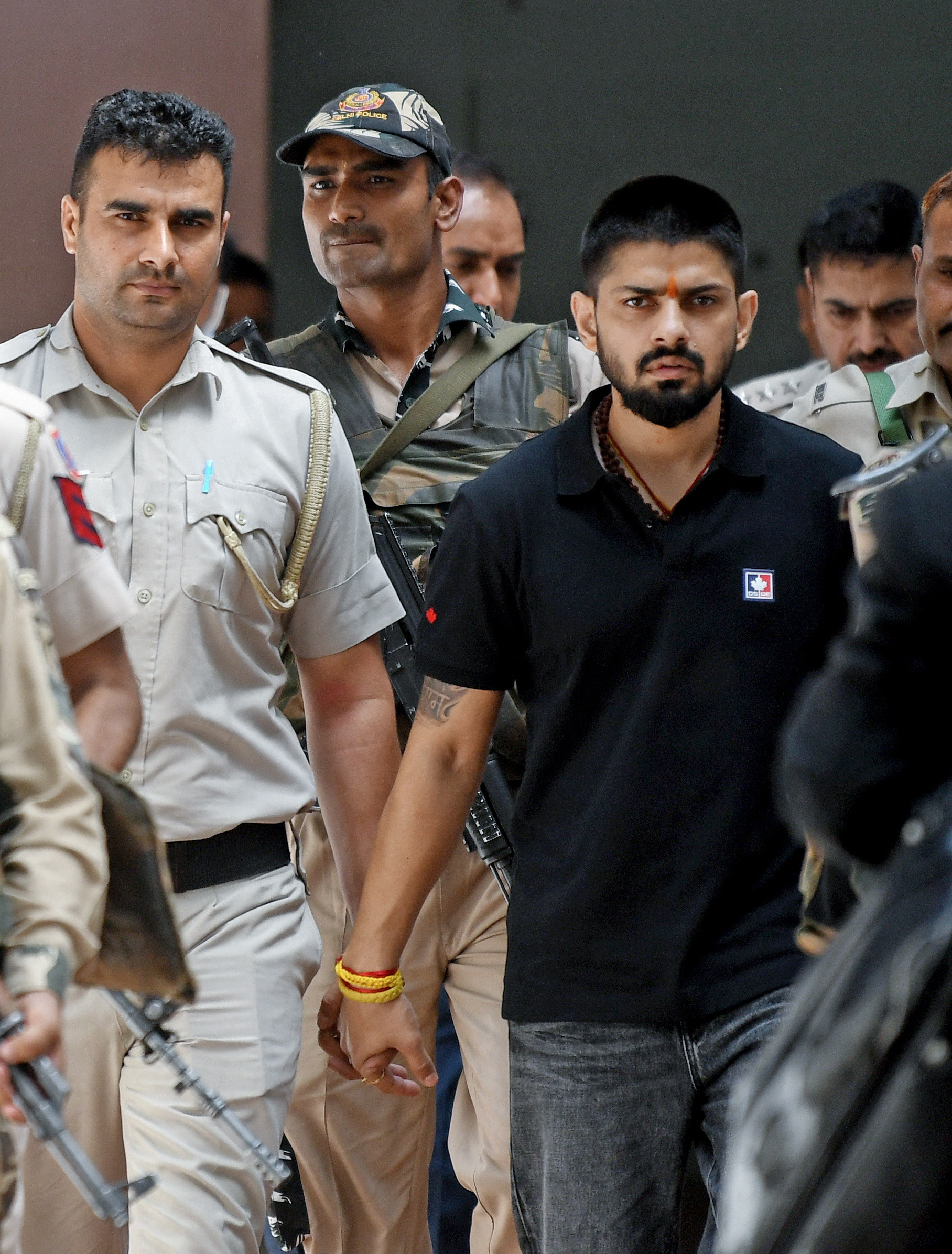 Policemen escort Lawrence Bishnoi at a court, in New Delhi