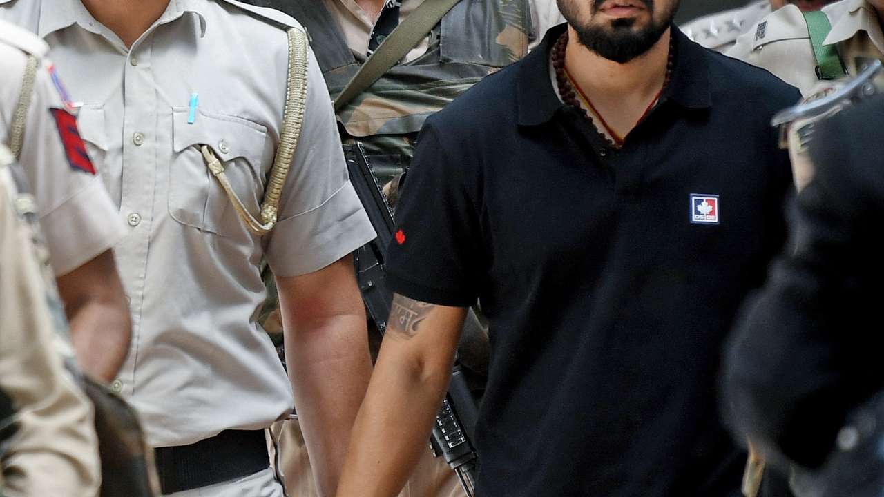 Policemen escort Lawrence Bishnoi at a court, in New Delhi