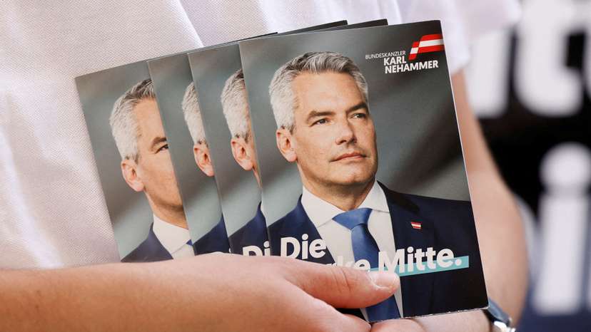 FILE PHOTO: A person holds pictures of Austrian Chancellor and head of Peoples Party Karl Nehammer in Vienna
