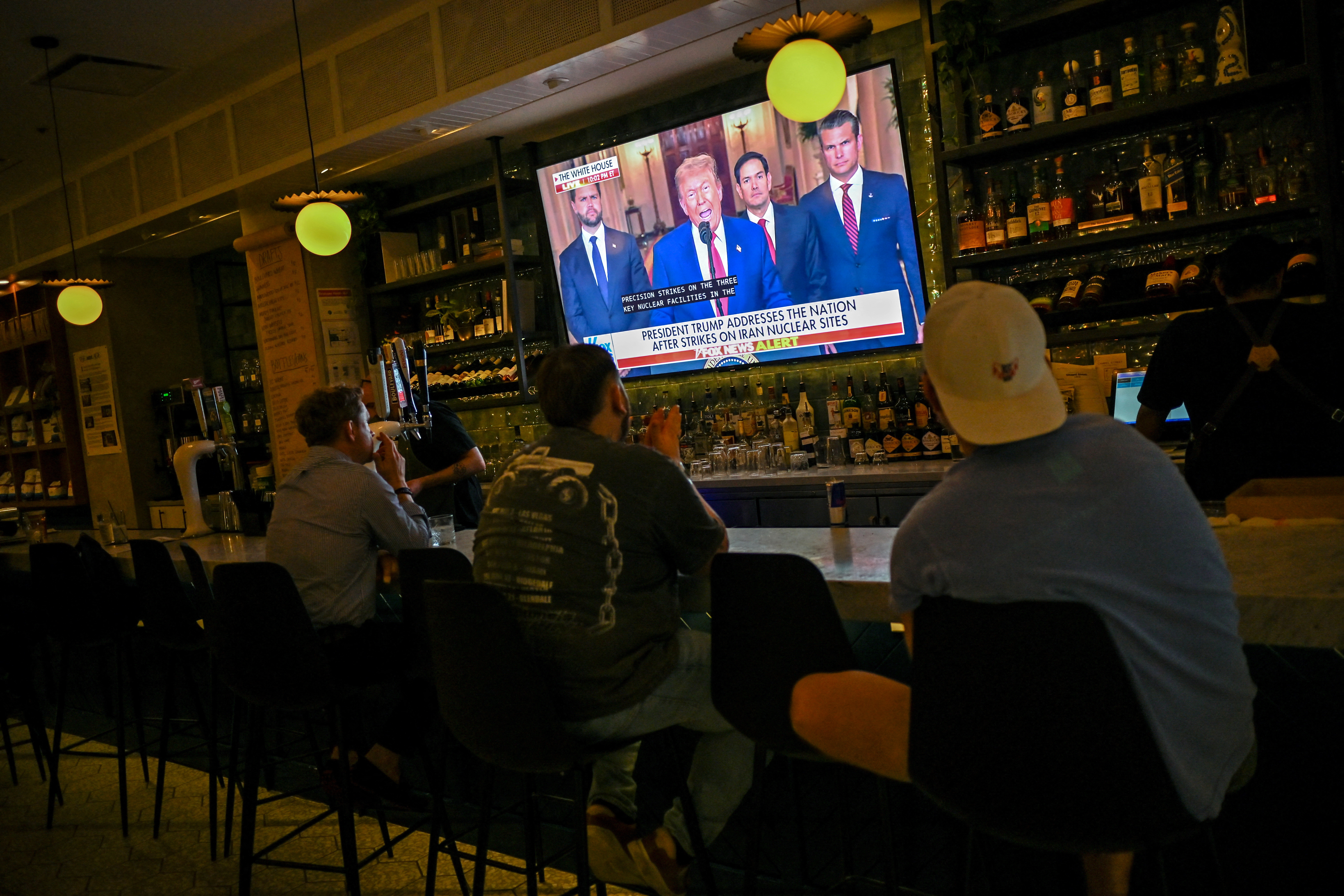Patrons of the Chapel Street Cafe watch as U.S. President Donald Trump delivers an address to the nation