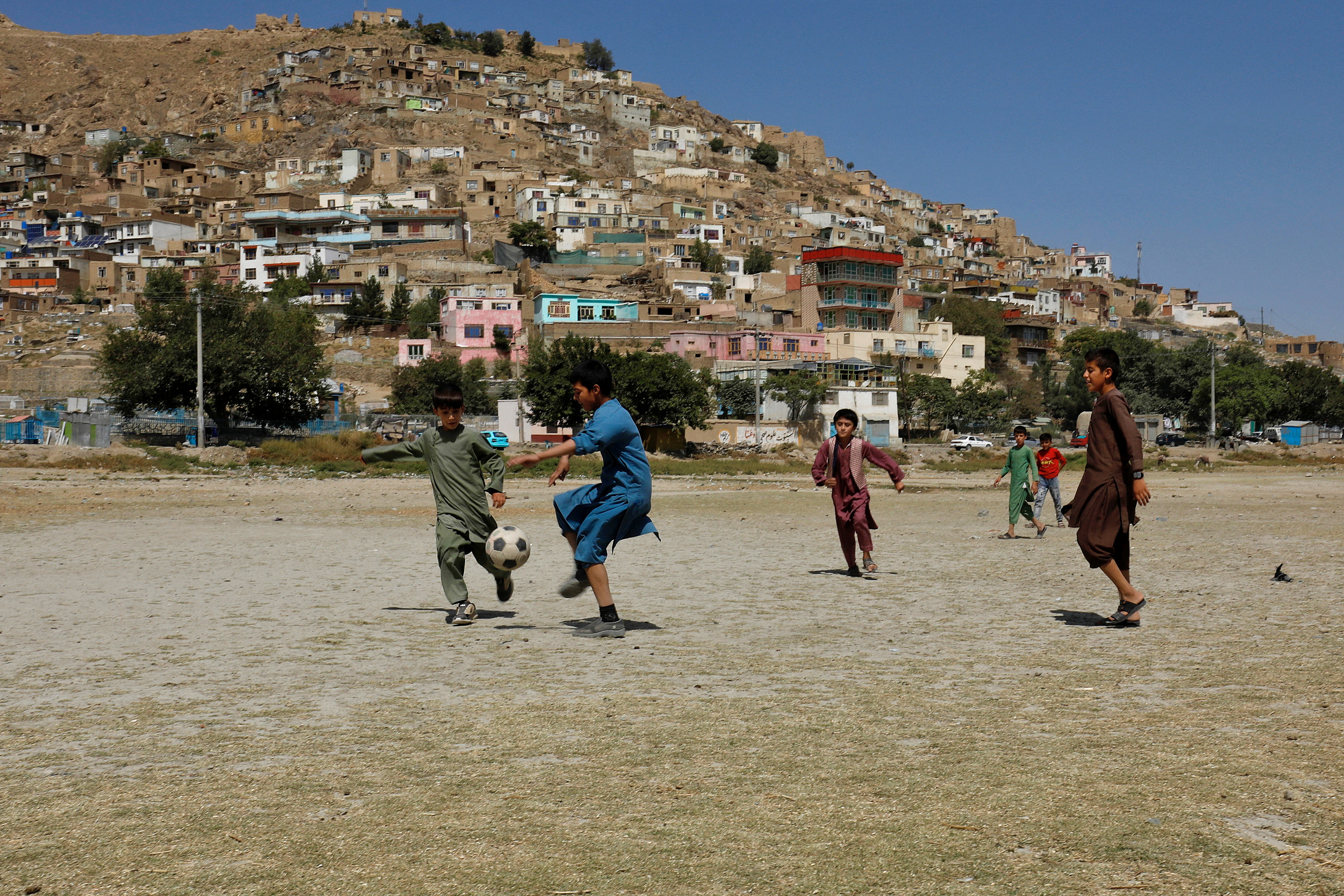 Afghan children play football in a playground in Kabul