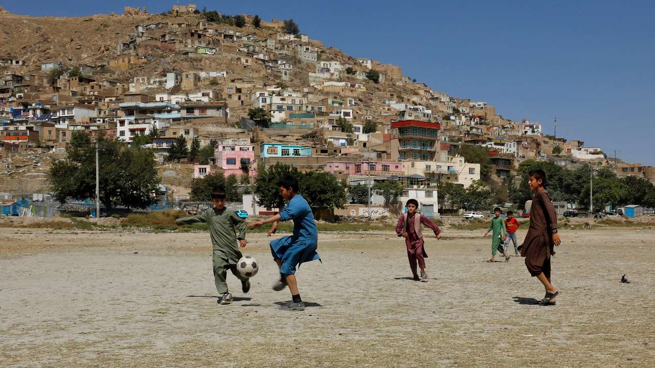 Afghan children play football in a playground in Kabul