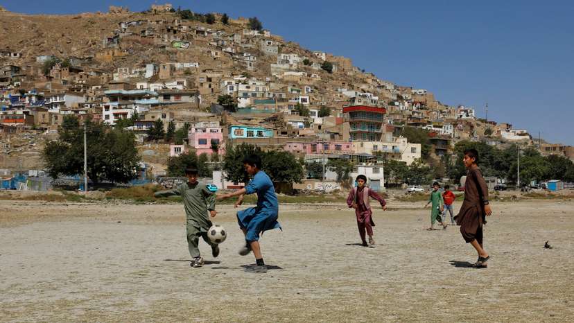Afghan children play football in a playground in Kabul