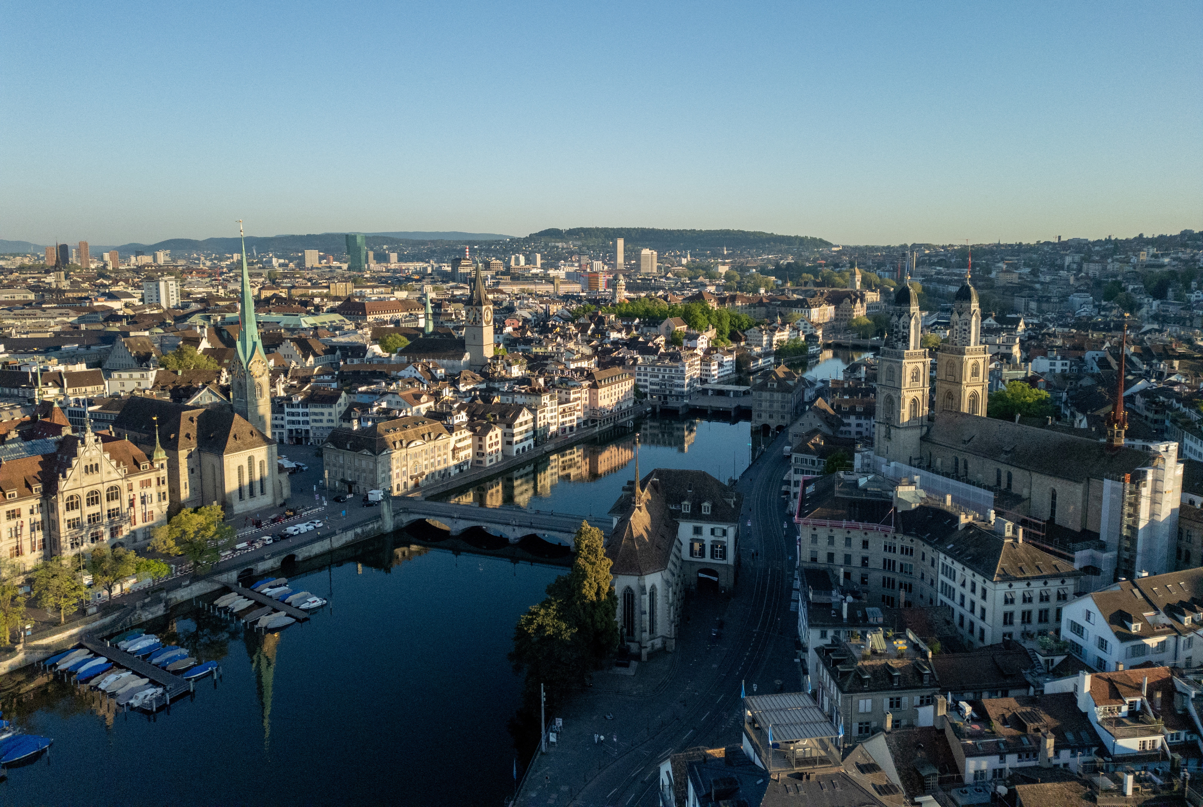 A drone view shows the Limmat river, the Grossmuenster and Fraumuenster churches and the city are seen early morning in Zurich