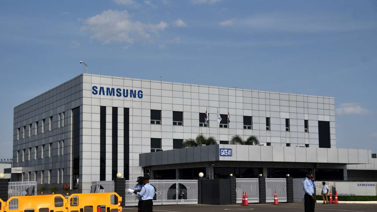 Security guards stand outside a Samsung facility during a strike by the factory workers demanding higher wages in Sriperumbudur