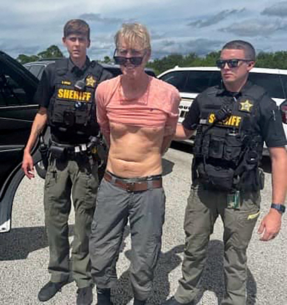 FILE PHOTO: Ryan W. Routh, suspected of attempting to assassinate U.S. President Donald Trump at his West Palm Beach golf course, stands handcuffed between two Martin County Sheriff's office deputies after his arrest during a traffic stop near Palm C