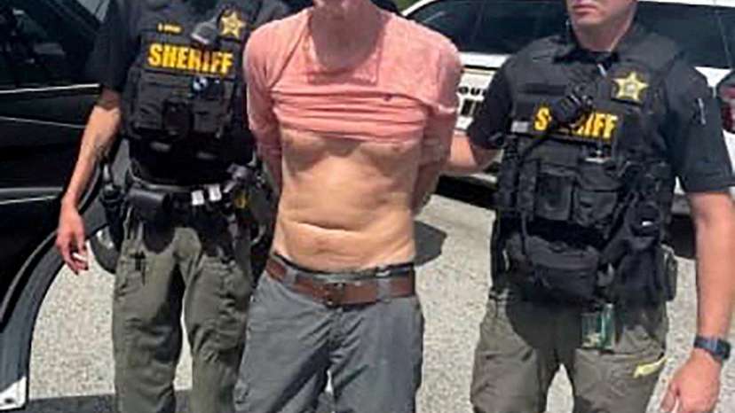 FILE PHOTO: Ryan W. Routh, suspected of attempting to assassinate U.S. President Donald Trump at his West Palm Beach golf course, stands handcuffed between two Martin County Sheriff's office deputies after his arrest during a traffic stop near Palm C