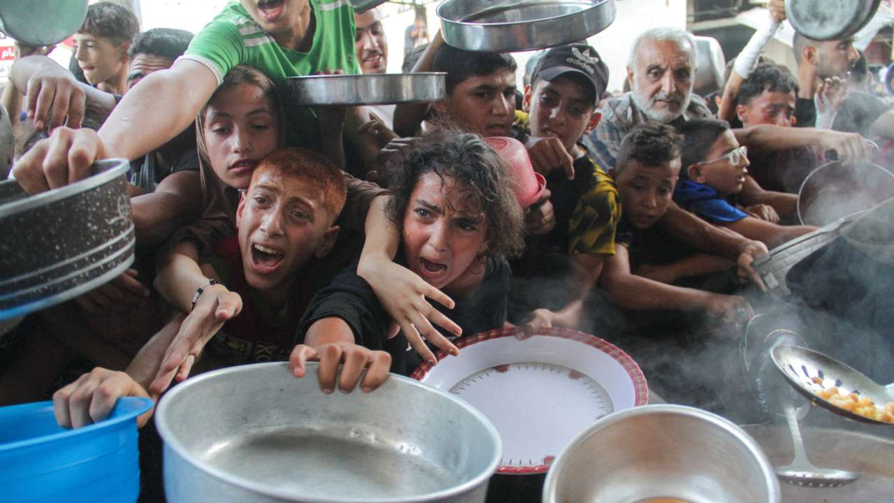 Palestinians gather to receive food cooked by a charity kitchen, amid the Israel-Hamas conflict, in the northern Gaza Strip