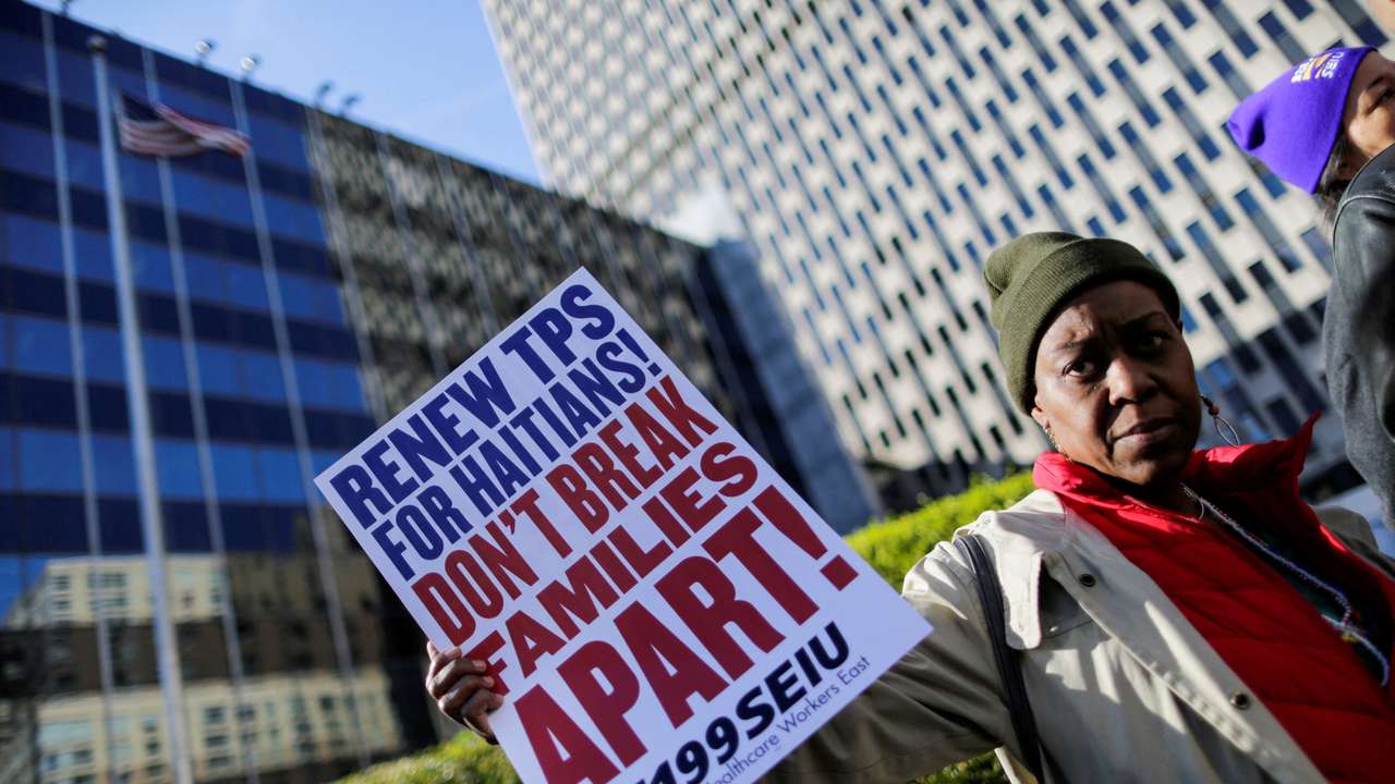 FILE PHOTO: A woman holds a placard as Haitian immigrants and supporters rally to reject DHS Decision to terminate TPS for Haitians, at the Manhattan borough in New York