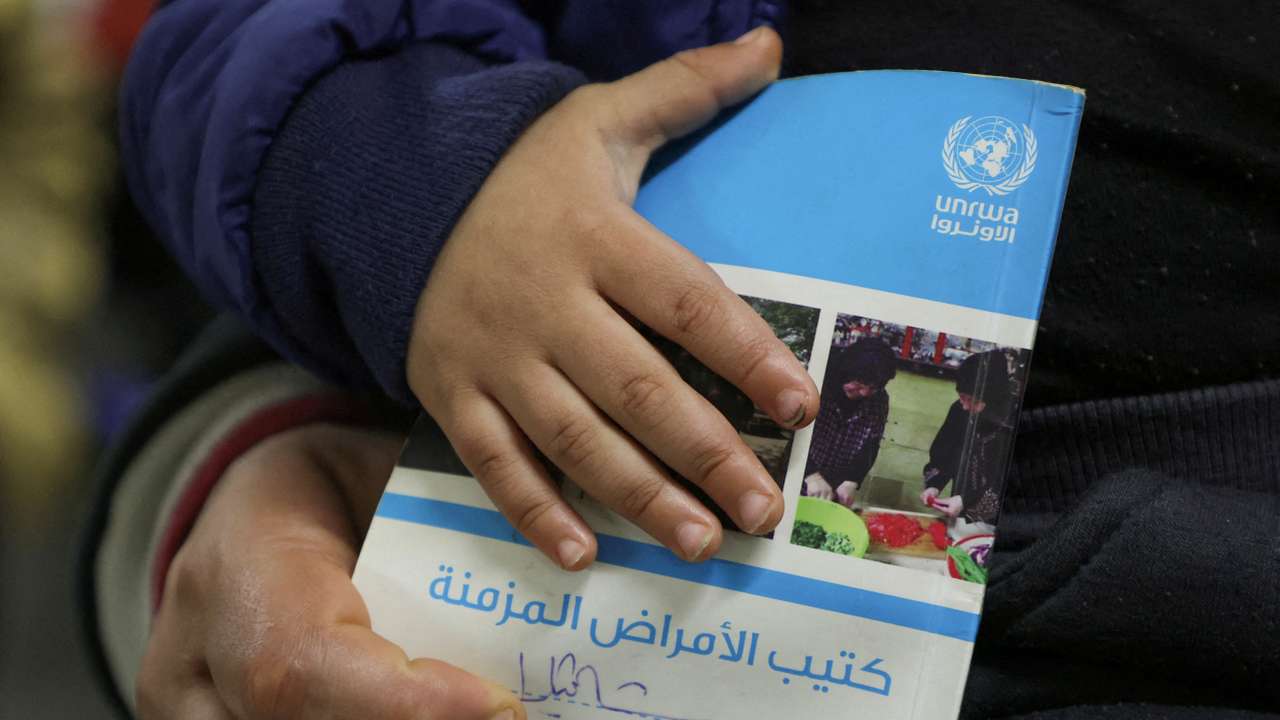 FILE PHOTO: A child holds a booklet as he waits inside a UNRWA health center at Shatila Palestinian refugee camp, in Beirut suburbs