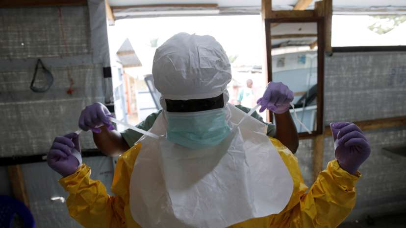 FILE PHOTO: A health worker puts on Ebola protection gear before entering the Biosecure Emergency Care Units at the Alima Ebola treatment centre in Beni