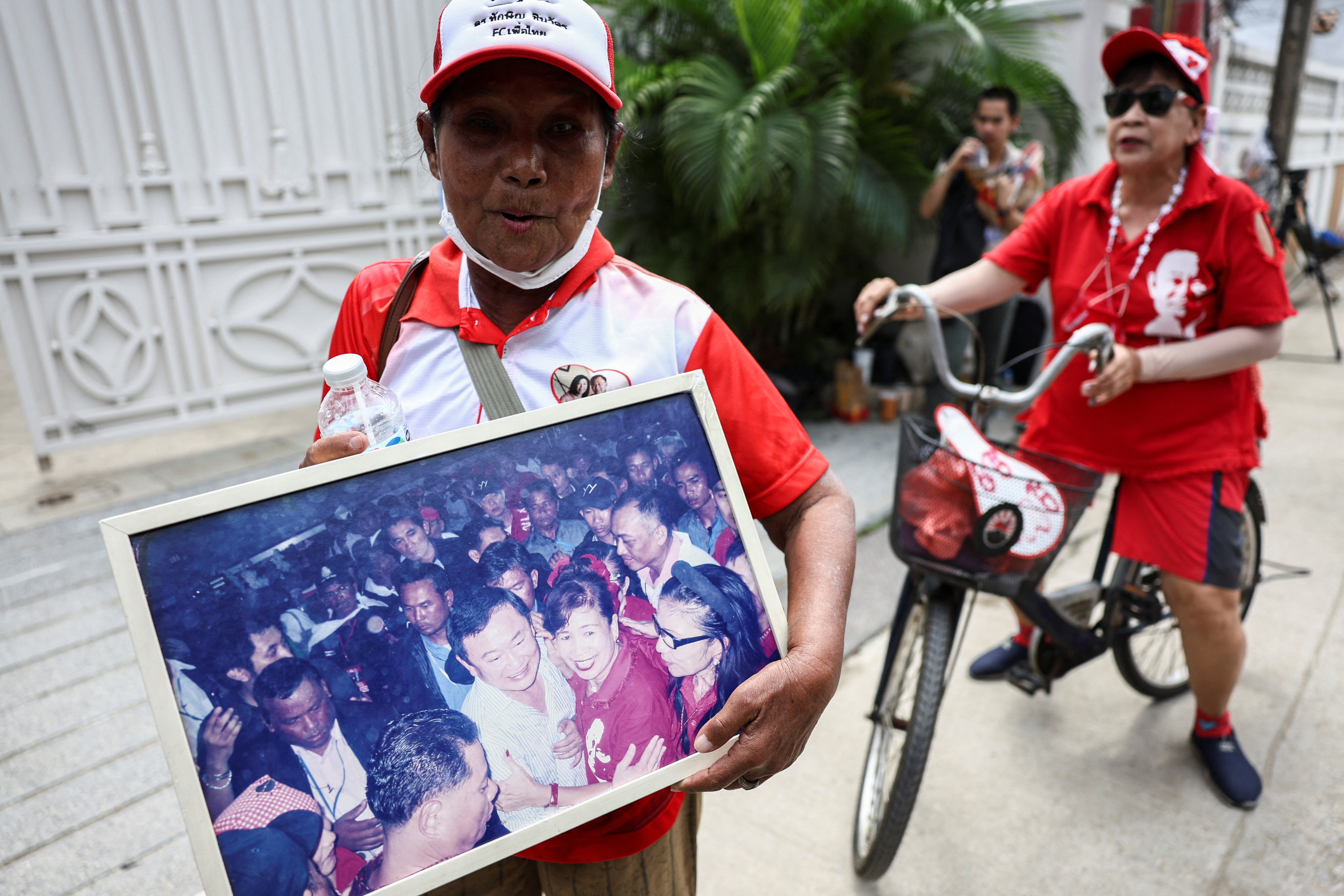 Supporters stand outside Thailand's former Prime Minister Thaksin Shinawatra's family compound in Bangkok