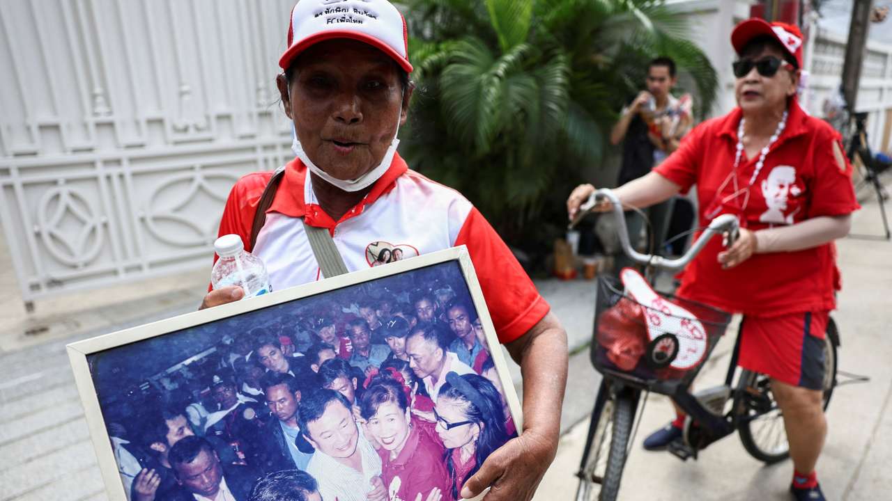 Supporters stand outside Thailand's former Prime Minister Thaksin Shinawatra's family compound in Bangkok