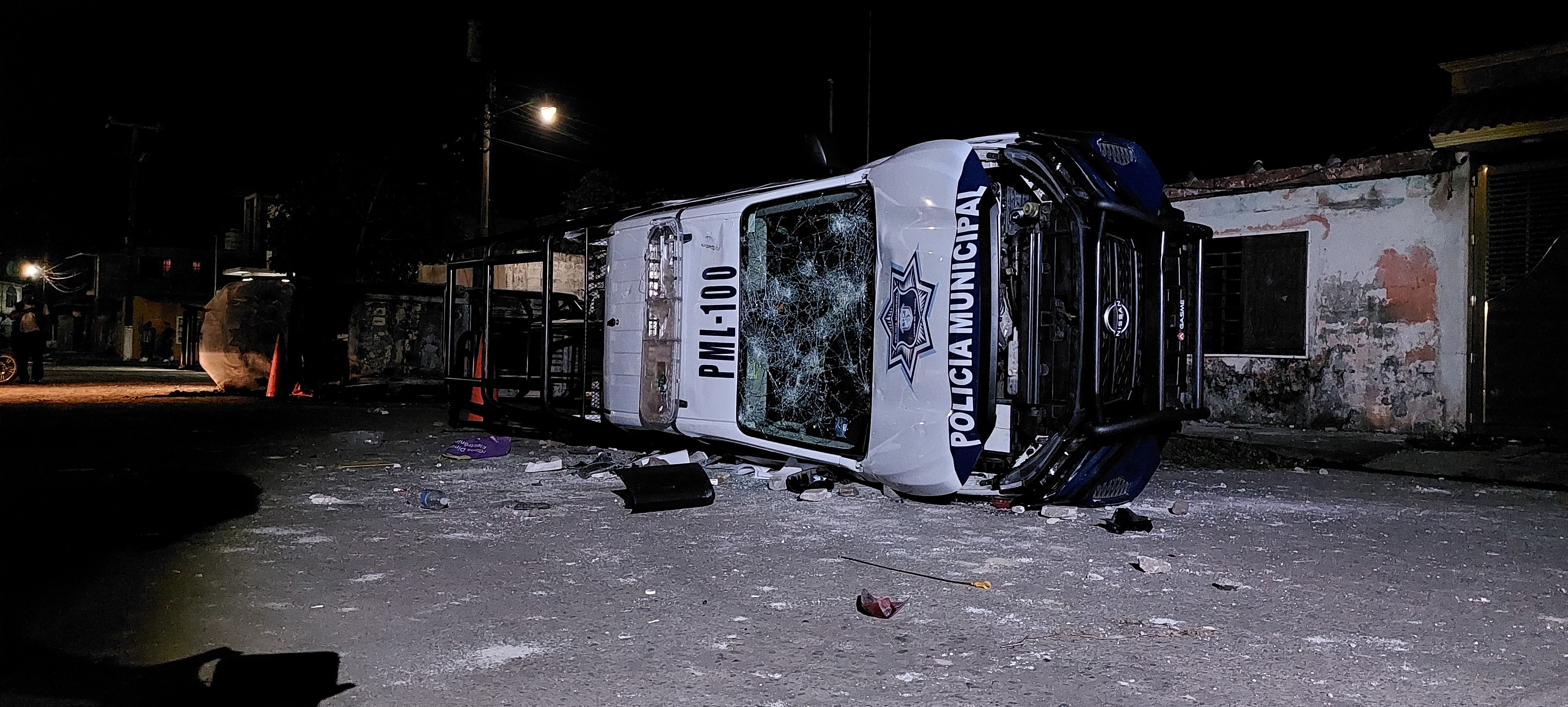A burnt police car lies overturned, following the death of a young man in Lerdo de Tejada