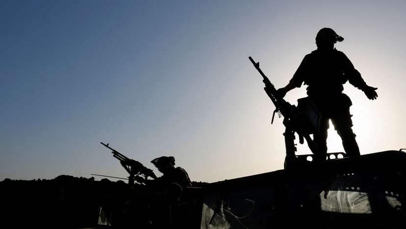 Israeli soldiers gather on the Israeli side of the Israel-Gaza border