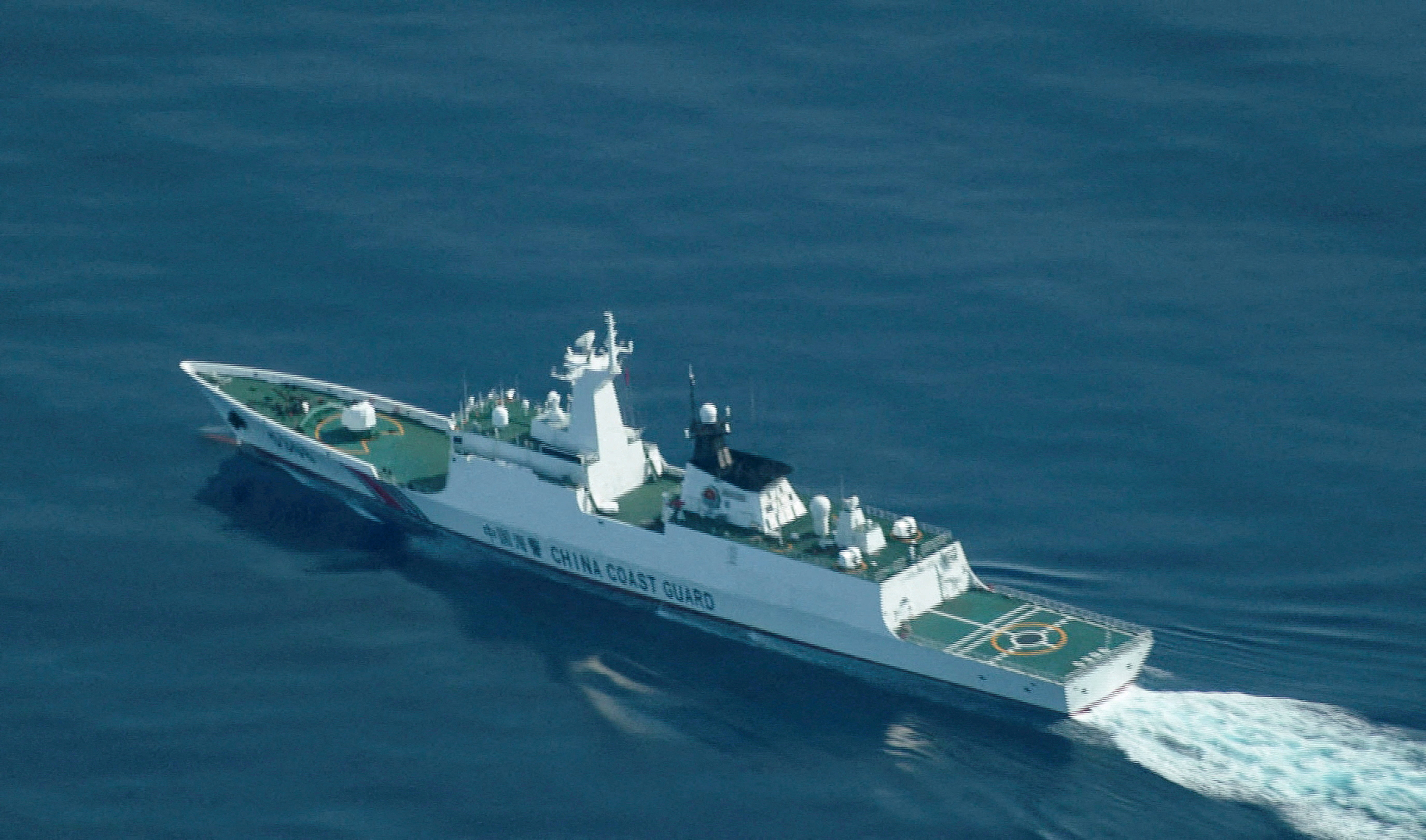 FILE PHOTO: An aerial view of a China Coast Guard ship navigating near the disputed Scarborough Shoal, as Philippine Coast Guard aircraft carrying journalists patrols the area