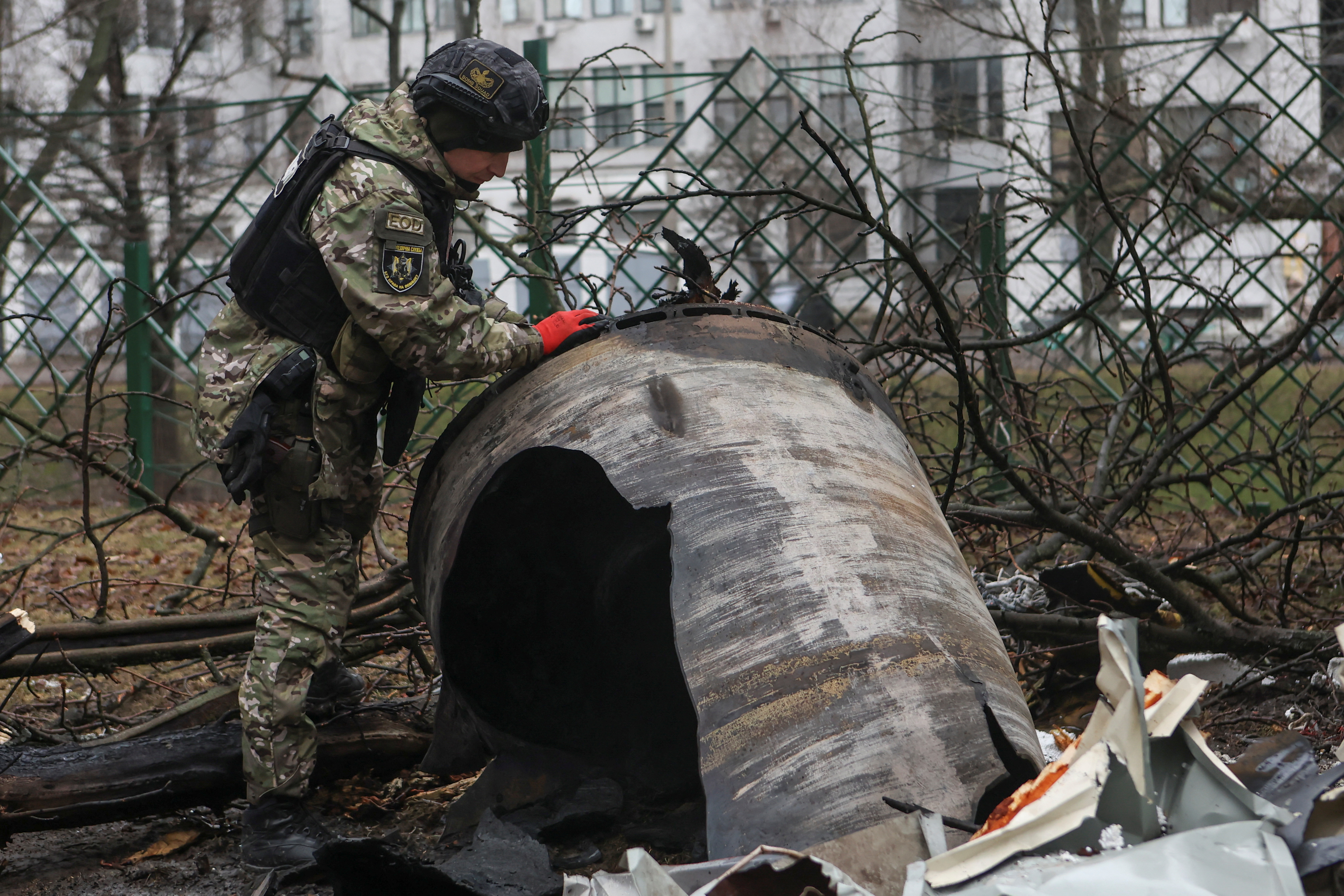 A bomb squad member works next to remains of an unidentified missile at the site where residential buildings were heavily damaged during a Russian missile attack in Kharkiv