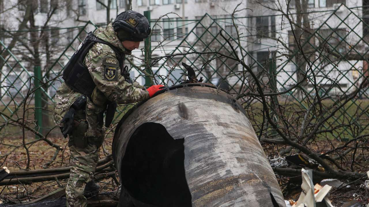A bomb squad member works next to remains of an unidentified missile at the site where residential buildings were heavily damaged during a Russian missile attack in Kharkiv