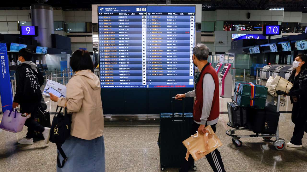 People look at flight information at Taiwan Taoyuan International Airport in Taoyuan,