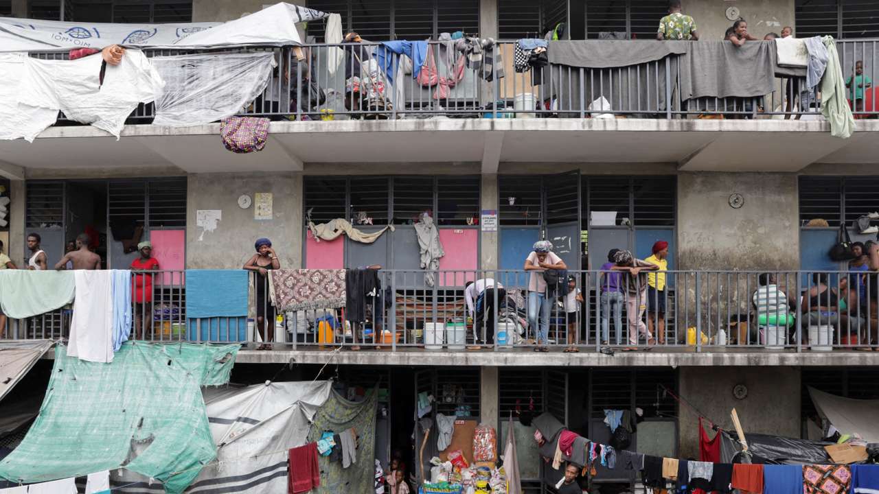 FILE PHOTO: People stand on balconies at the Ecole Nationale Argentine Bellegarde, a school turned into a shelter for some of the more than 1.3 million Haitians who have been internally displaced due to gang violence, in Port-au-Prince, Haiti, October 27, 2025. REUTERS/Patrice Noel/File Photo