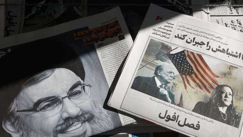 A newspaper with a picture of Trump and Harris is seen next to a newspaper with a picture of late Lebanon's Hezbollah leader Nasrallah, in Tehran
