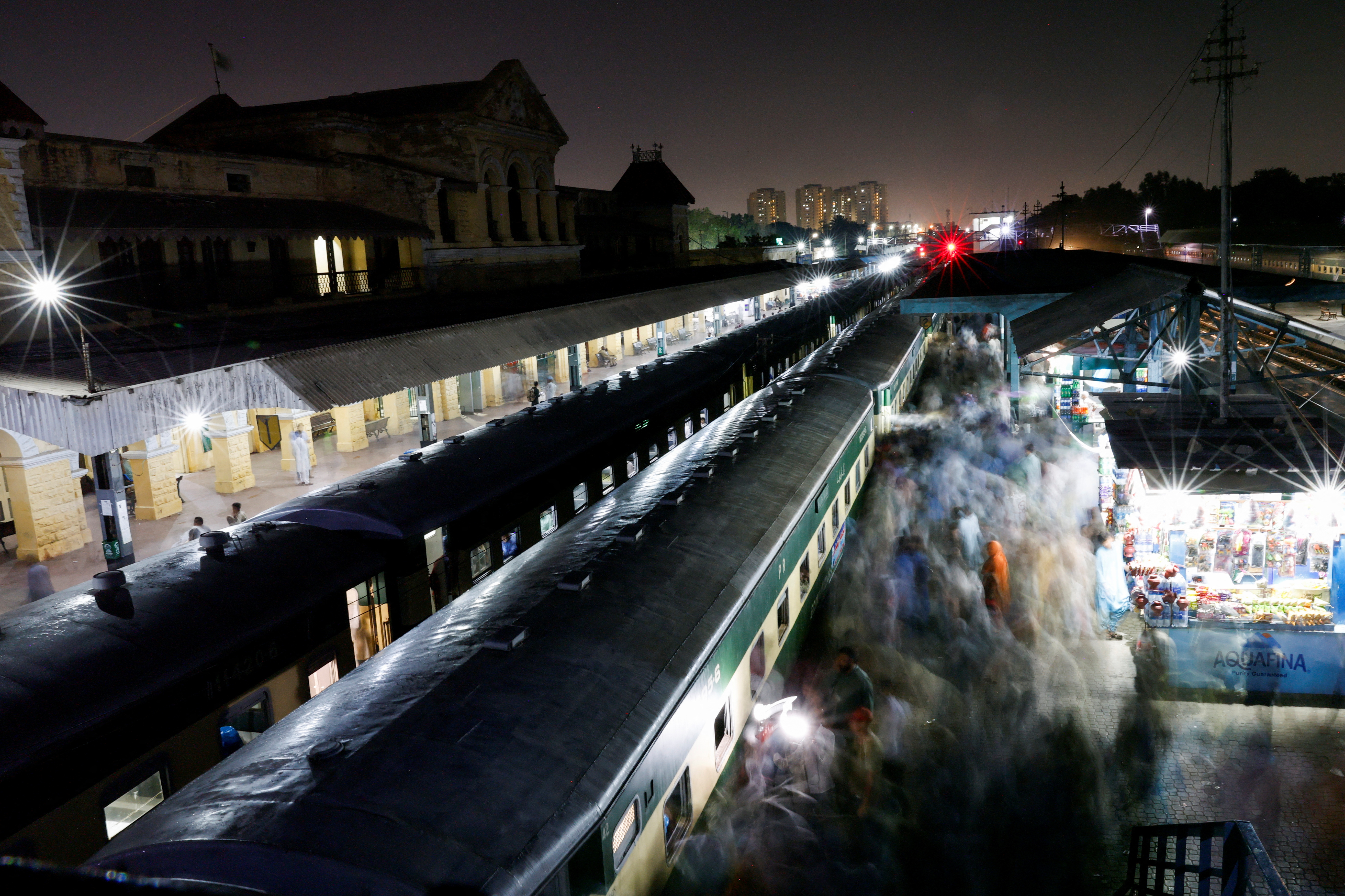 Passengers get on board a train to leave for their hometown to celebrate Eid al-Fitr with their family, at the Cantonment railway station in Karachi