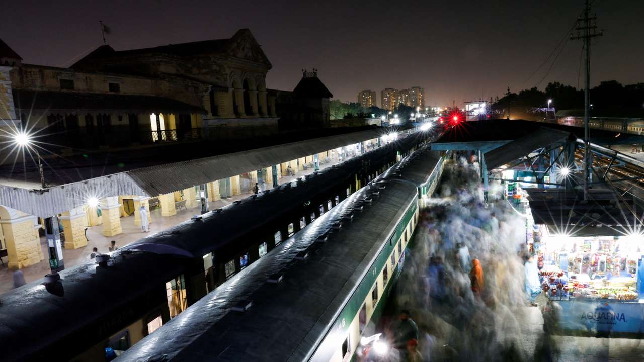Passengers get on board a train to leave for their hometown to celebrate Eid al-Fitr with their family, at the Cantonment railway station in Karachi