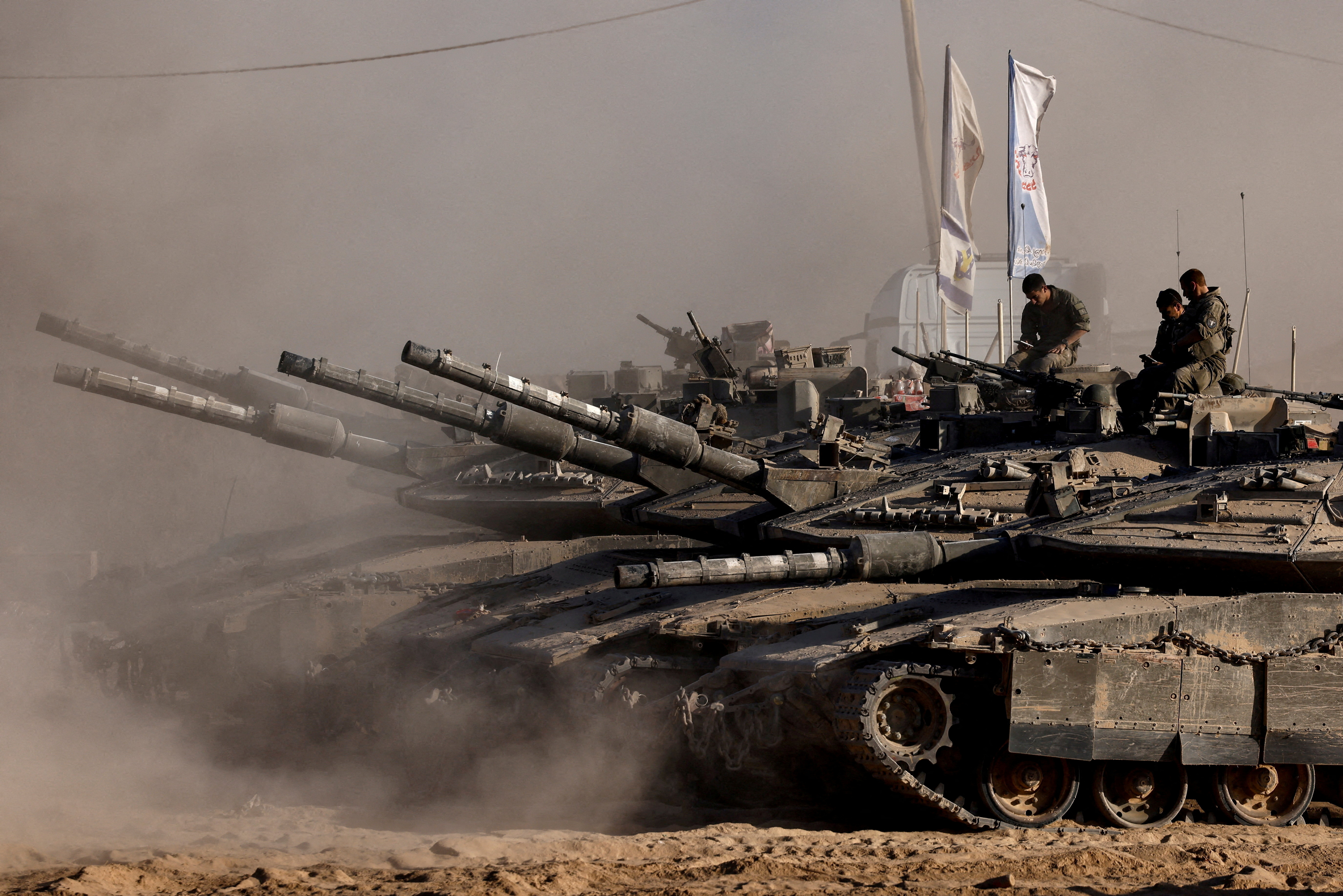 FILE PHOTO: Israeli soldiers sit on top of tanks at the Israel-Gaza border