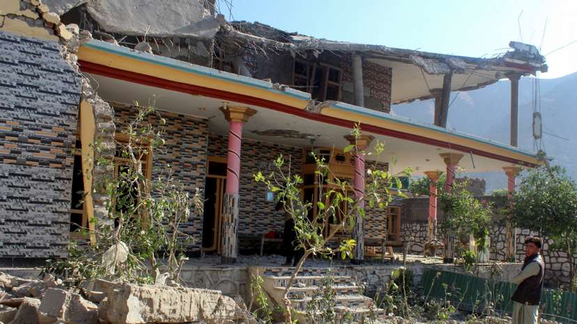 A man stands in front of a damaged house that the Afghan Taliban government said was damaged after Pakistan carried out raids, in Asadabad