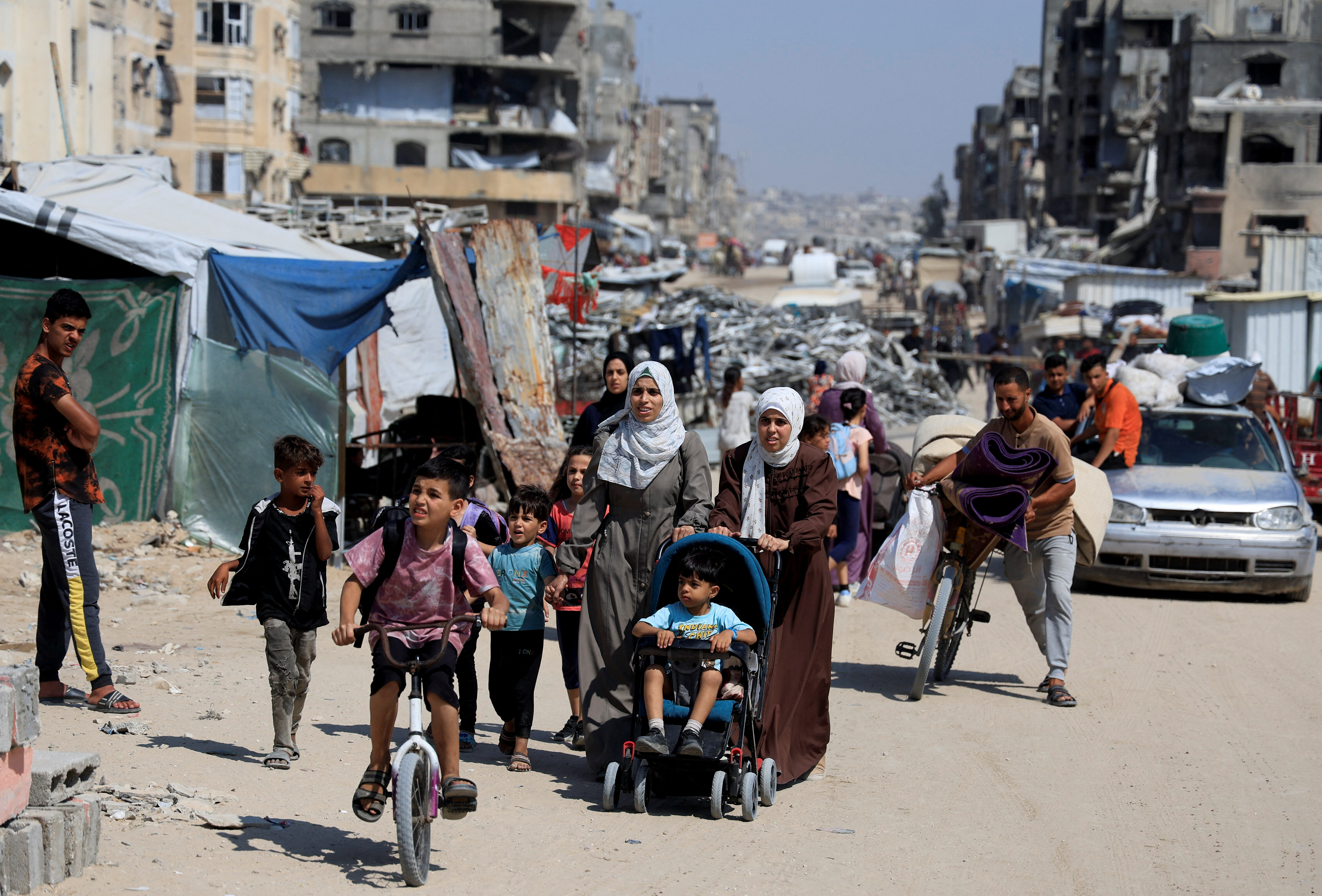 Palestinians carry their belongings as they flee their homes after the Israeli army issued evacuation, in Khan Younis