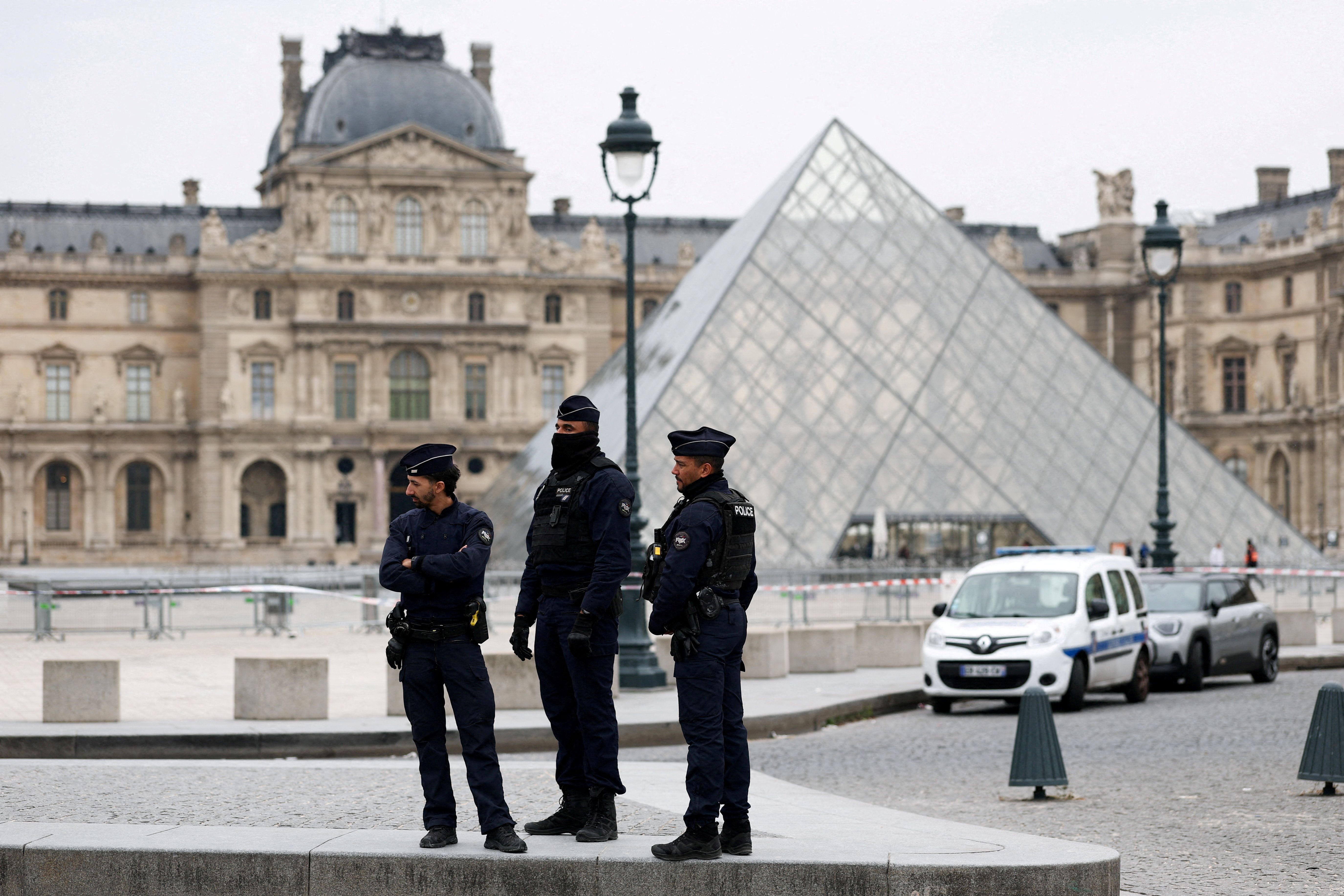 FILE PHOTO: Police stand near the pyramid of the Louvre museum after reports of a robbery, in Paris