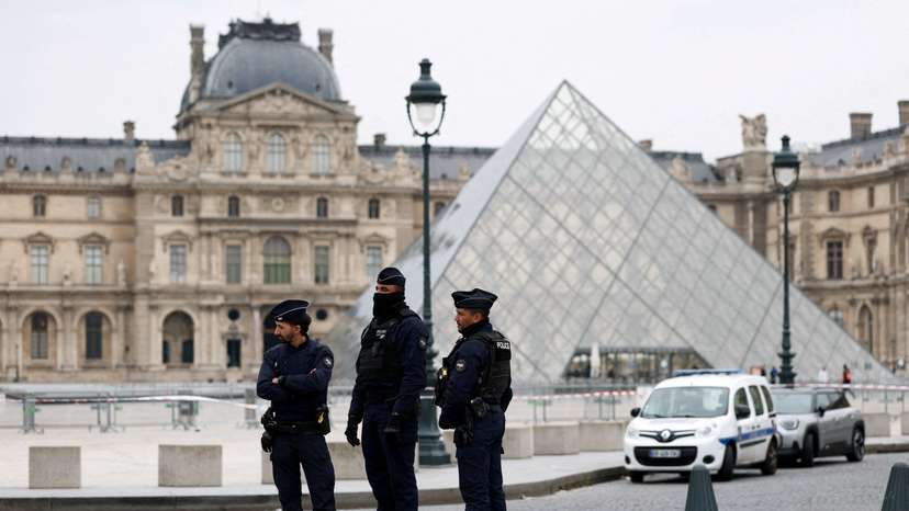 FILE PHOTO: Police stand near the pyramid of the Louvre museum after reports of a robbery, in Paris