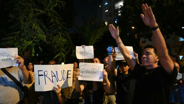 Demonstrators show signs that read in Spanish, "Fraud," as they take part in a protest following the first results of the presidential election in front of the National Jury of Elections (JNE) headquarters in Lima on April 12, 2026. Right-wing candidate Keiko Fujimori led exit polls following Peru's troubled presidential election on April 12, 2026, but failed to avoid a runoff after a tight vote marred by irregularities and a police raid on the country's election authority. (Photo by Luis ROBAYO / AFP)