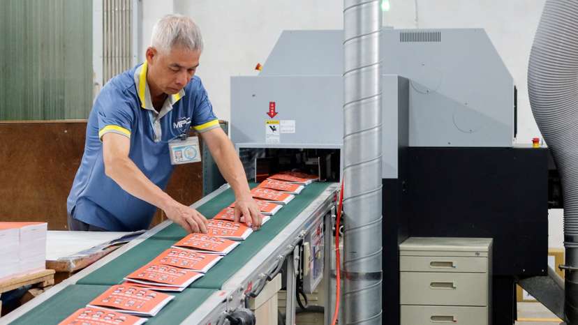 A worker handles copies of Taiwan's updated civil defence handbook at a printing house in Taoyuan