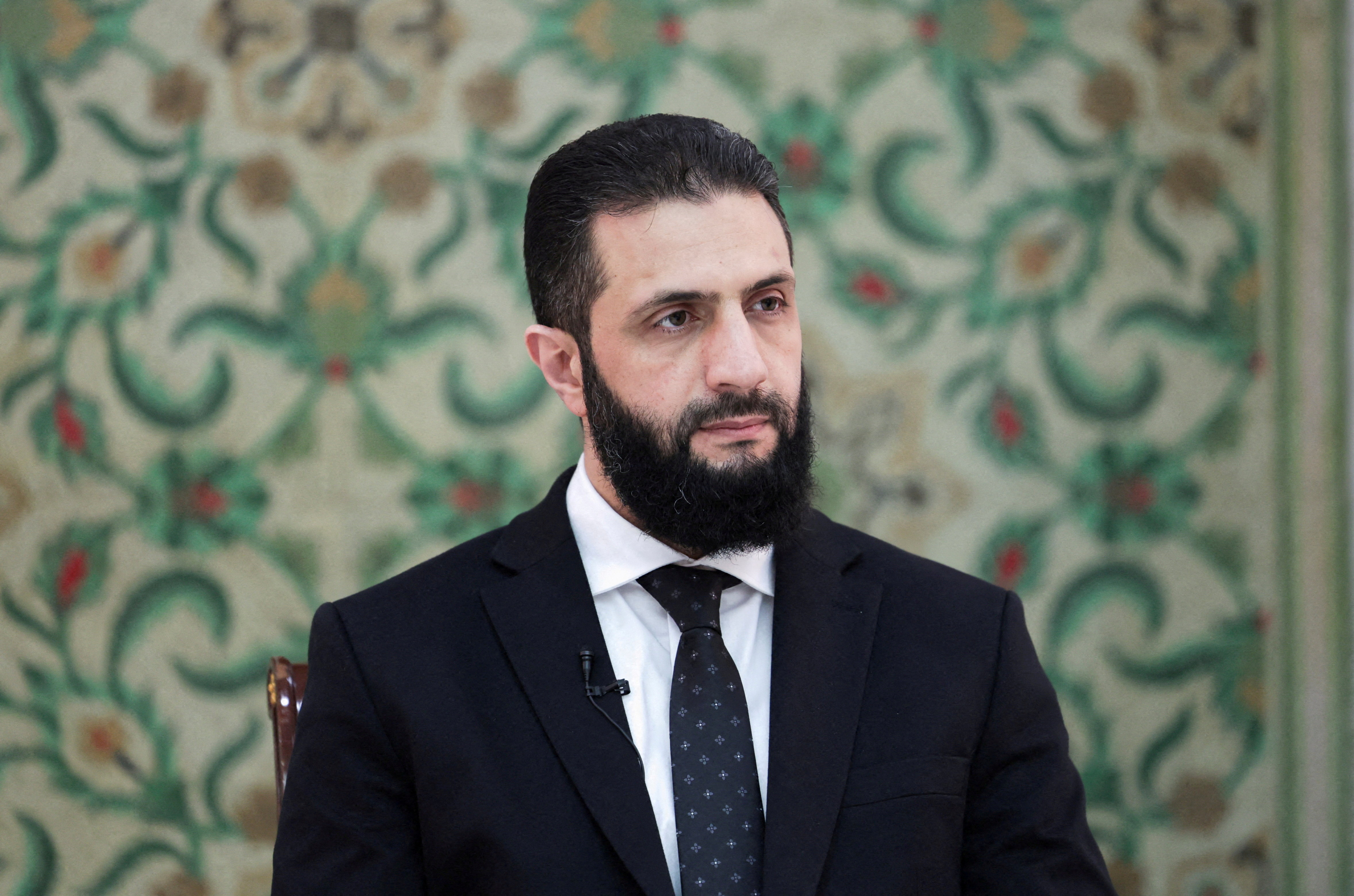 FILE PHOTO: Syria’s interim President Ahmed al-Sharaa attends an interview with Reuters